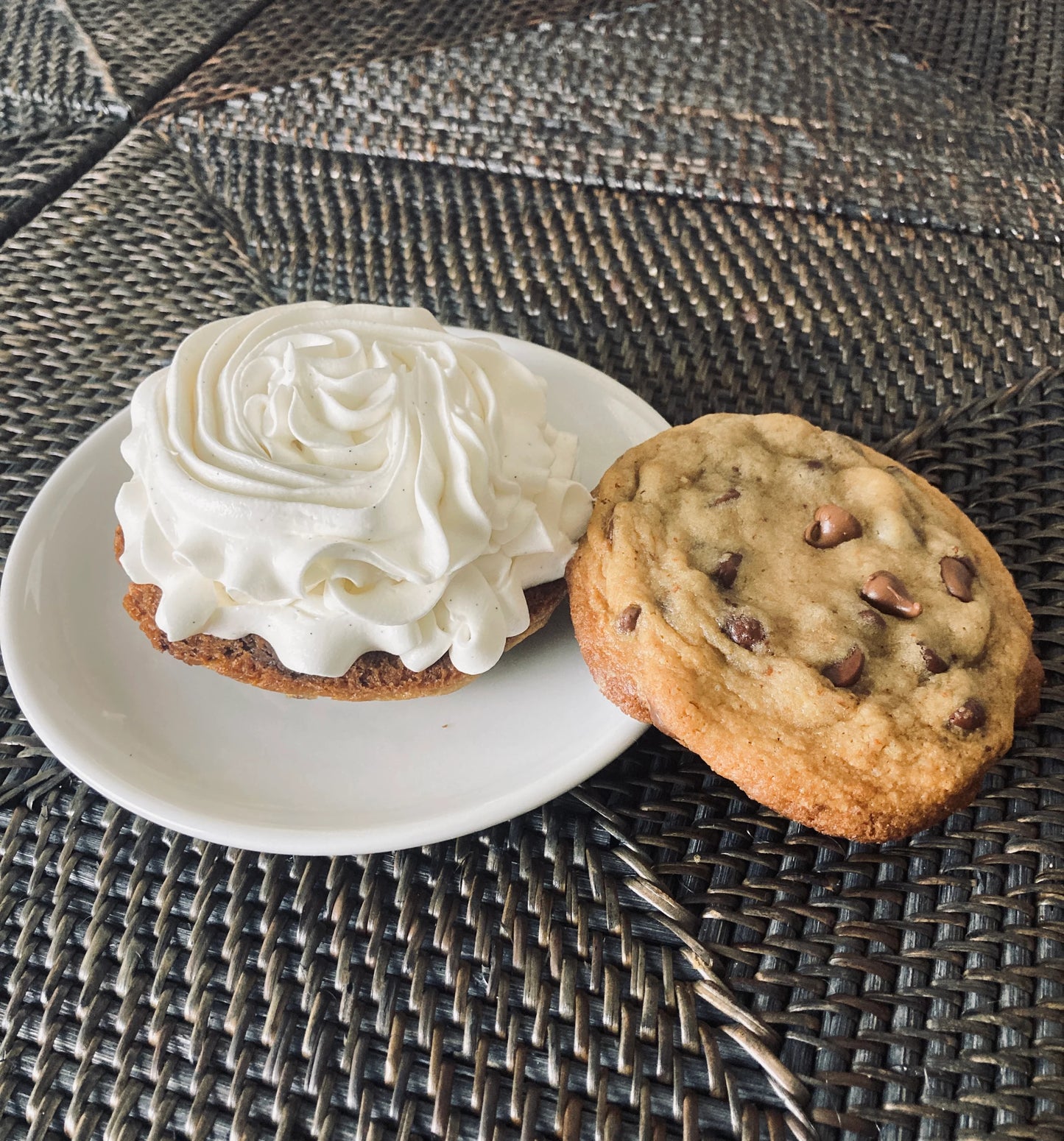 Two cookies on a white plate with a textured surface background